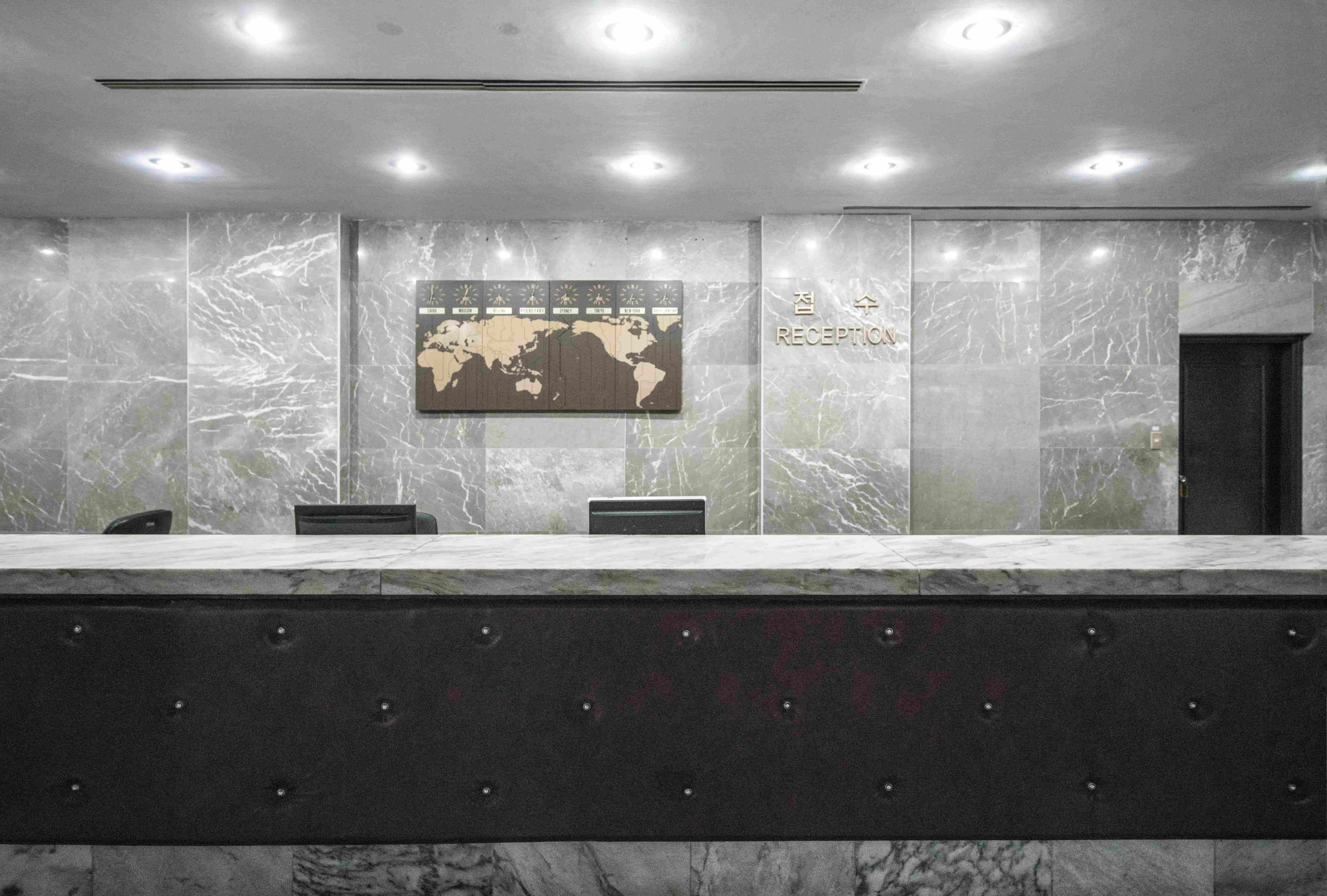 Professional reception area with marble desk and world map, symbolising global reach